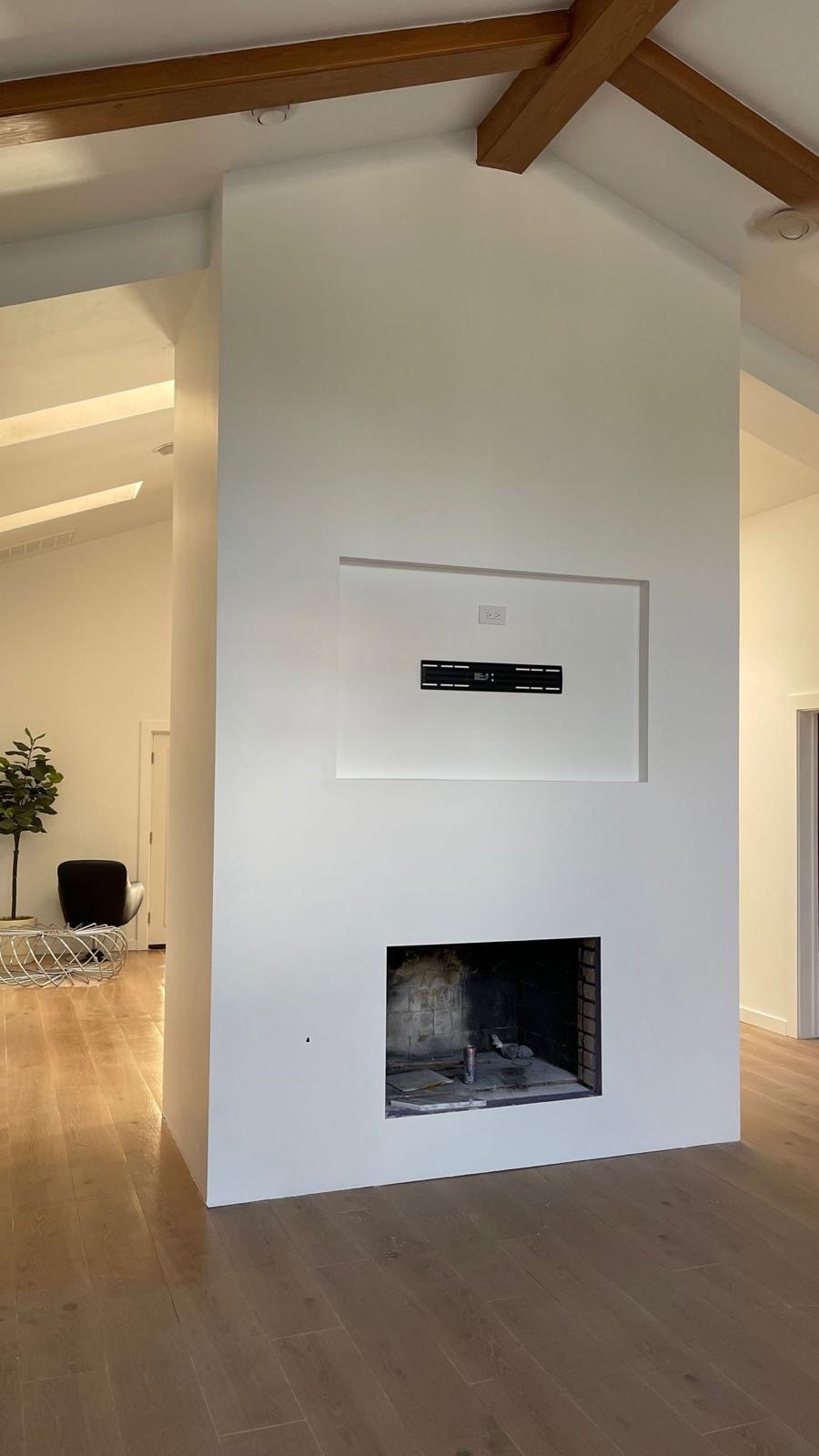Modern minimalist fireplace and TV wall remodel with vaulted wood beam ceiling
