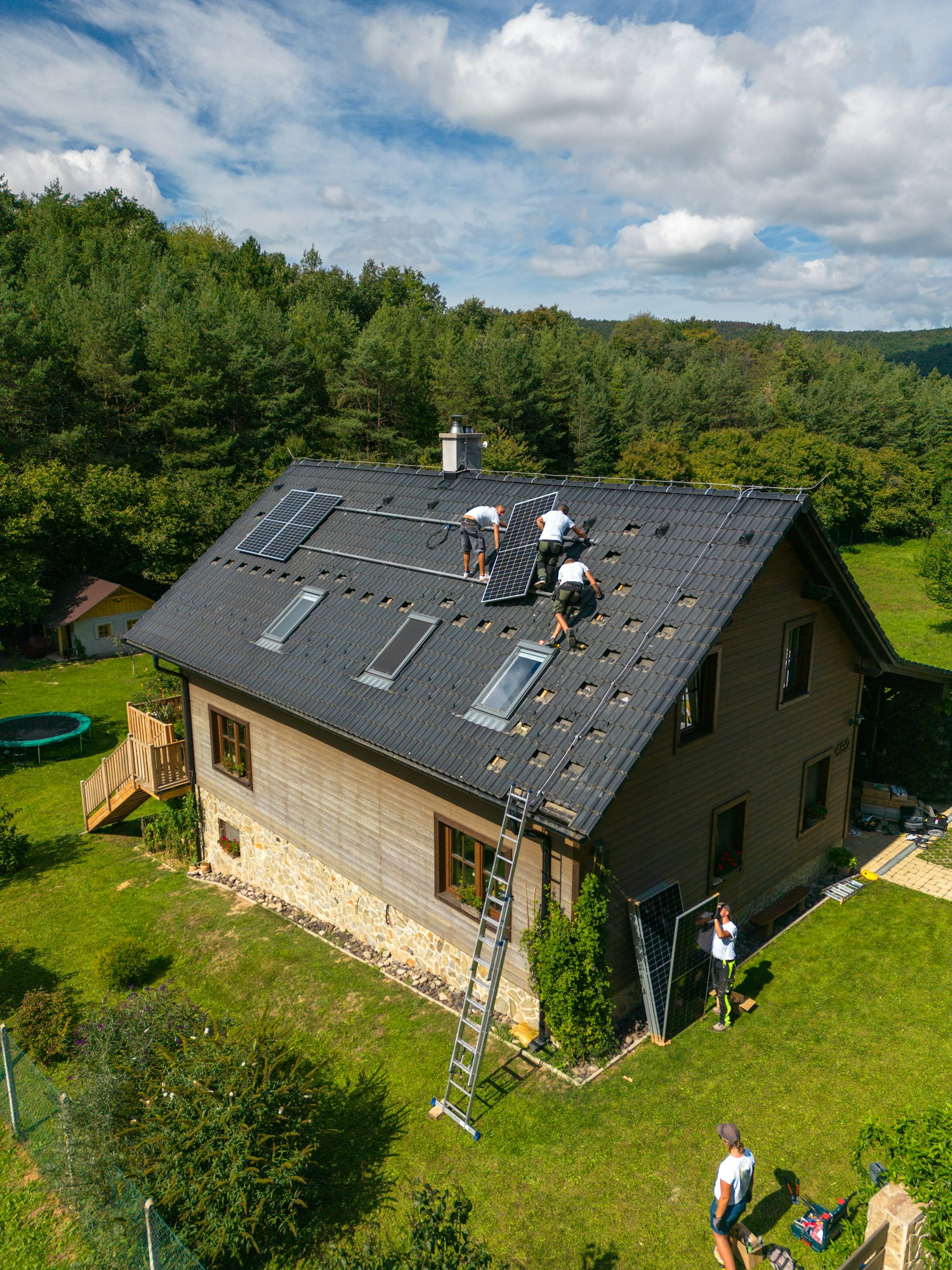 Men worker installing solar photovoltaic panels on roof, alternative energy, saving resources and
